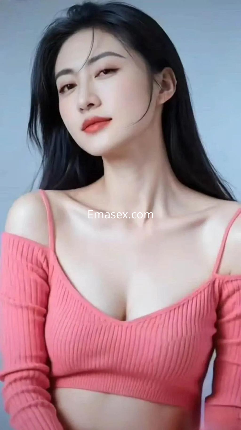 Escort en Zaragoza con cabello largo y oscuro, vistiendo un top rosa de mangas caídas y una expresión atractiva.