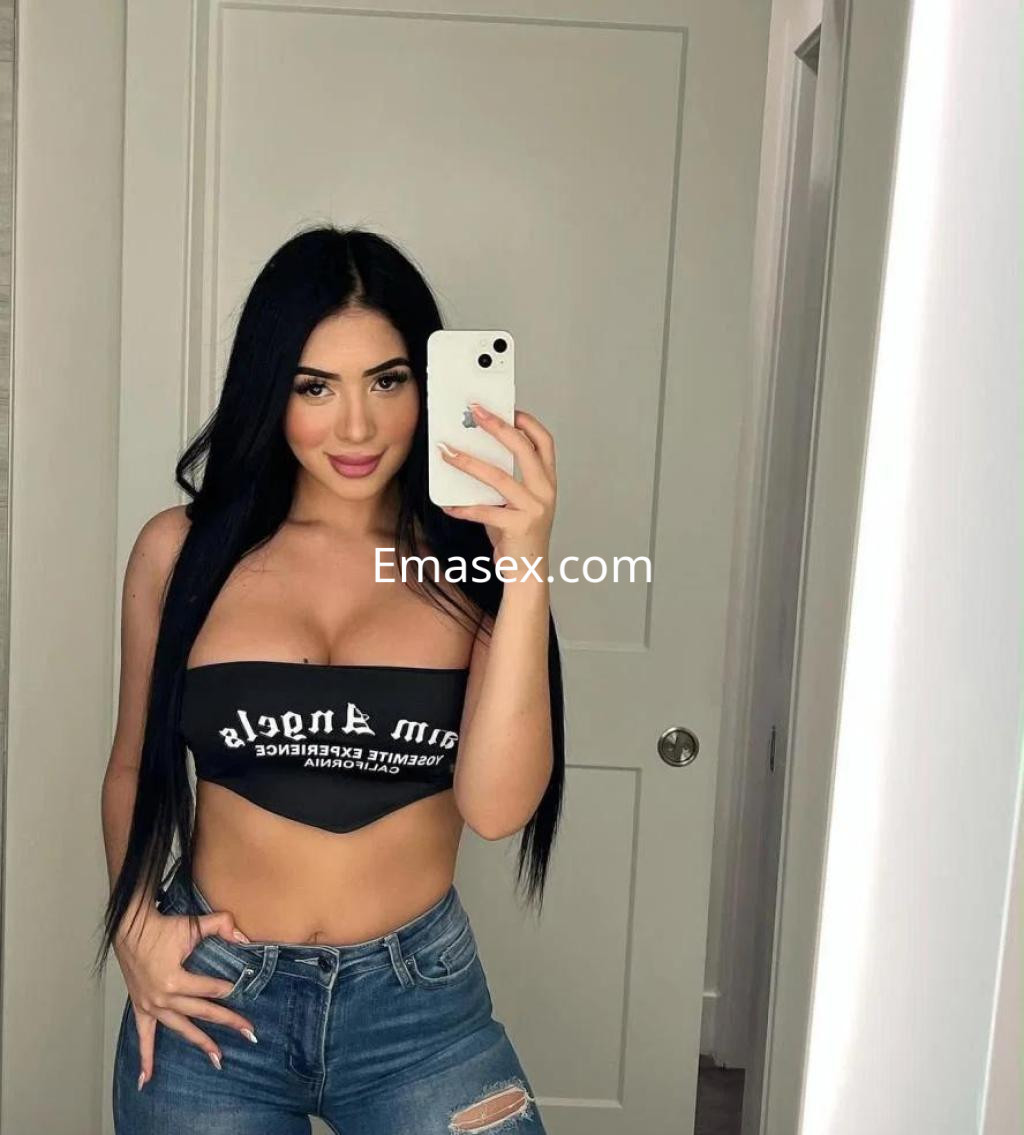 La puta se toma una selfie en un espejo, vistiendo un top negro y jeans ajustados en Palma de Mallorca.