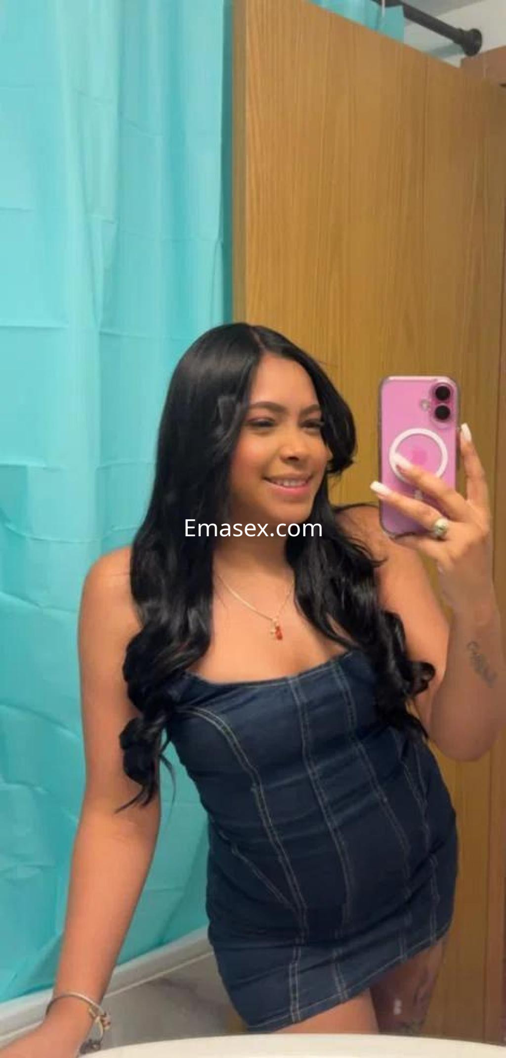 La puta luce un vestido ajustado y sin mangas, con cabello largo y suelto, en un baño de Cádiz.