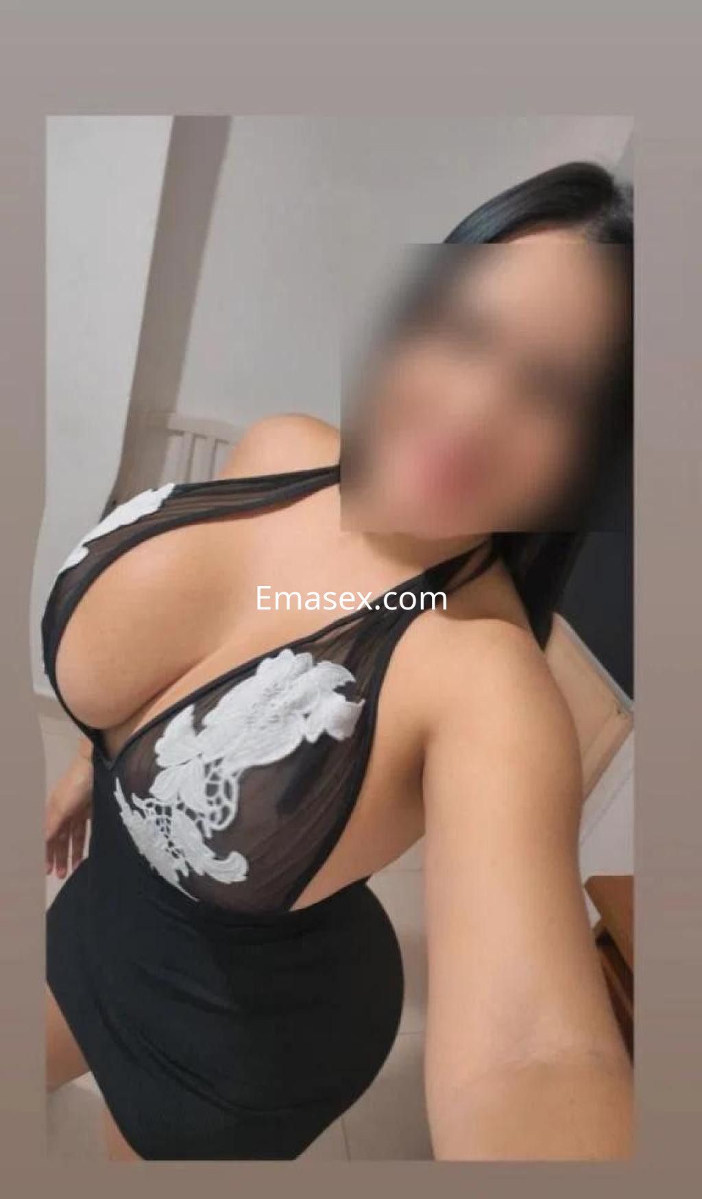 Escort en Córdoba posando con un vestido negro ajustado y un top de encaje transparente en un ambiente interior.