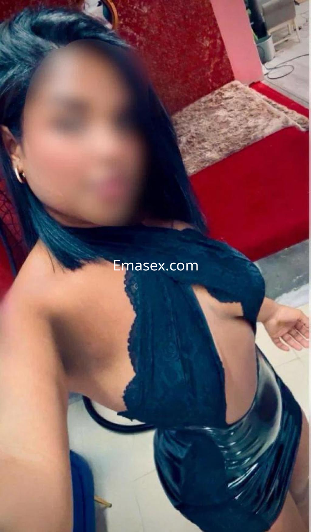 Escort en Tenerife viste un vestido negro ajustado con detalles de encaje, posando en un ambiente acogedor.