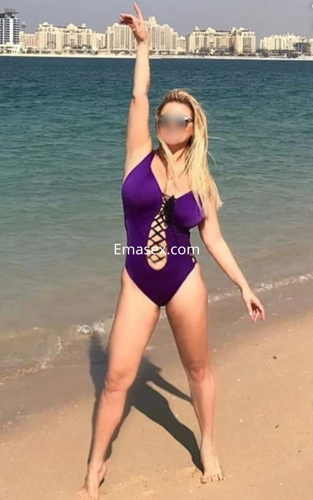 La puta luce un bañador morado con detalles en la playa, mostrando su figura junto al mar en Granada.