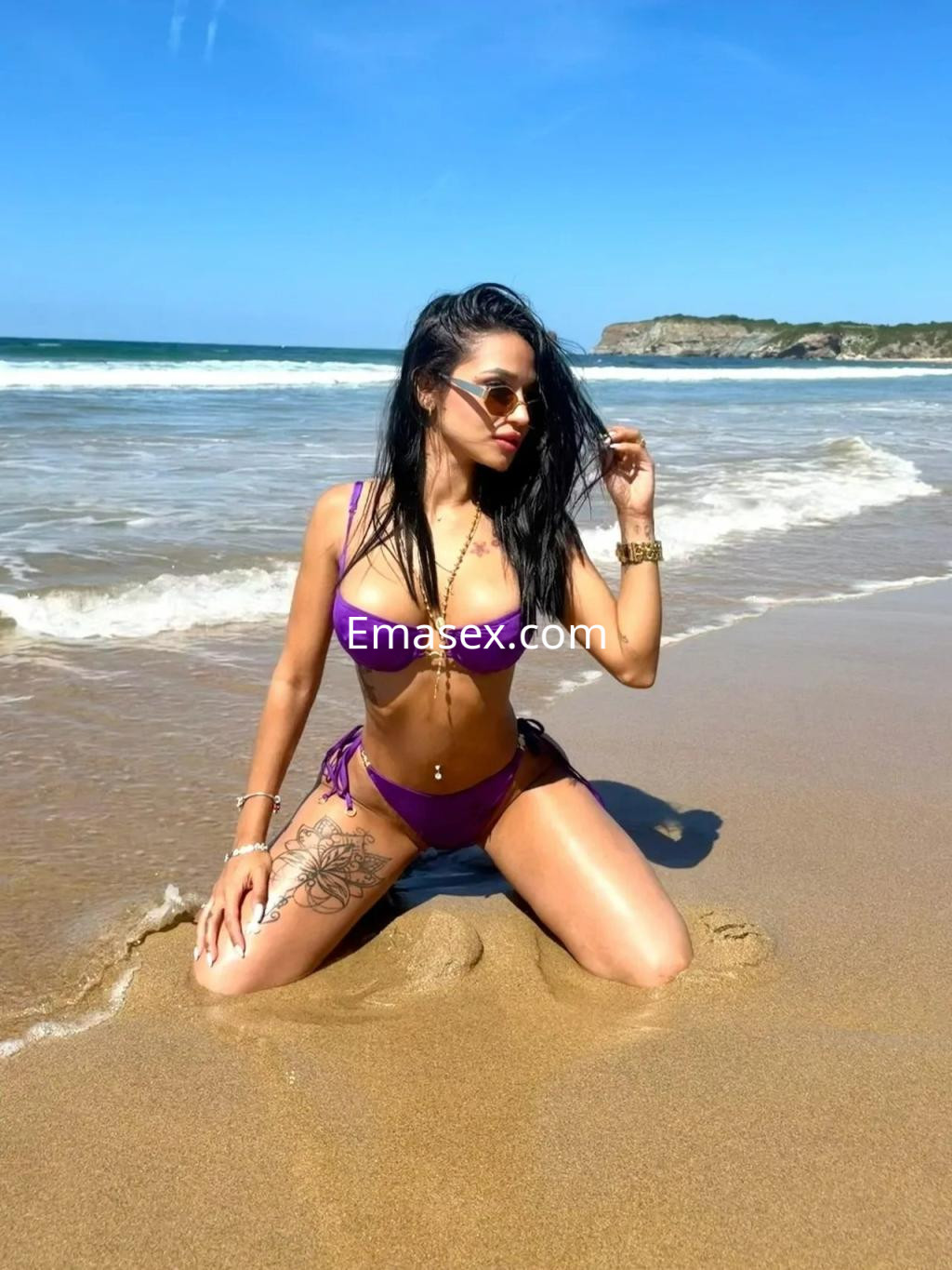 La puta está en la playa de Zaragoza, luciendo un bikini morado, gafas de sol y posando en la arena.