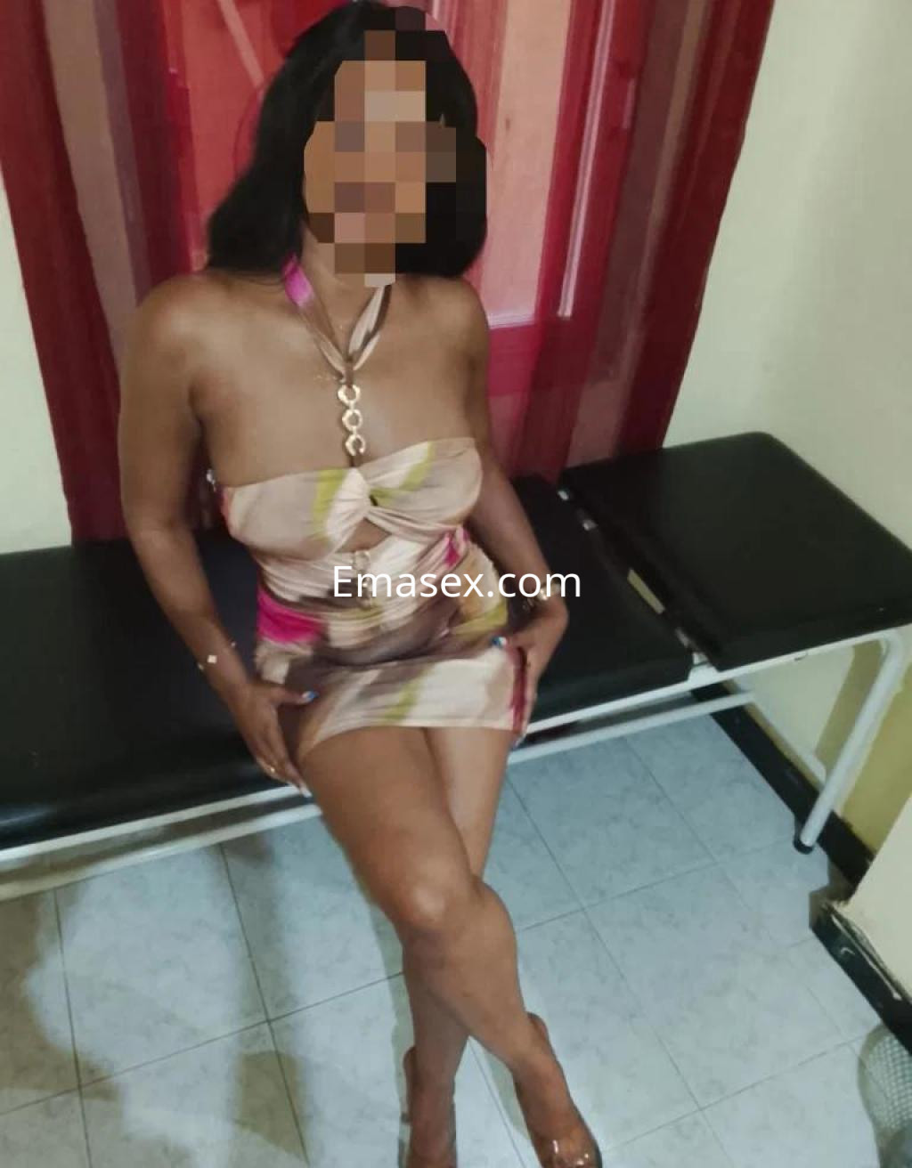 Escort en Alicante, sentada con un vestido corto y sin mangas, mostrando un estilo elegante y sofisticado.