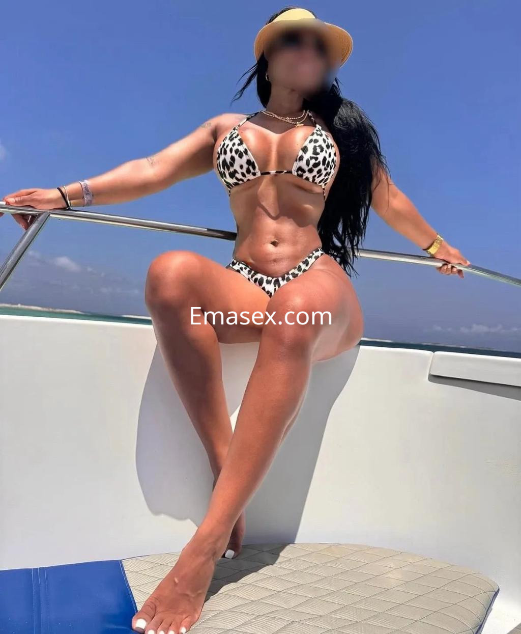 La puta luce un bikini de leopardo y un sombrero, posando con confianza en un yate en Málaga.
