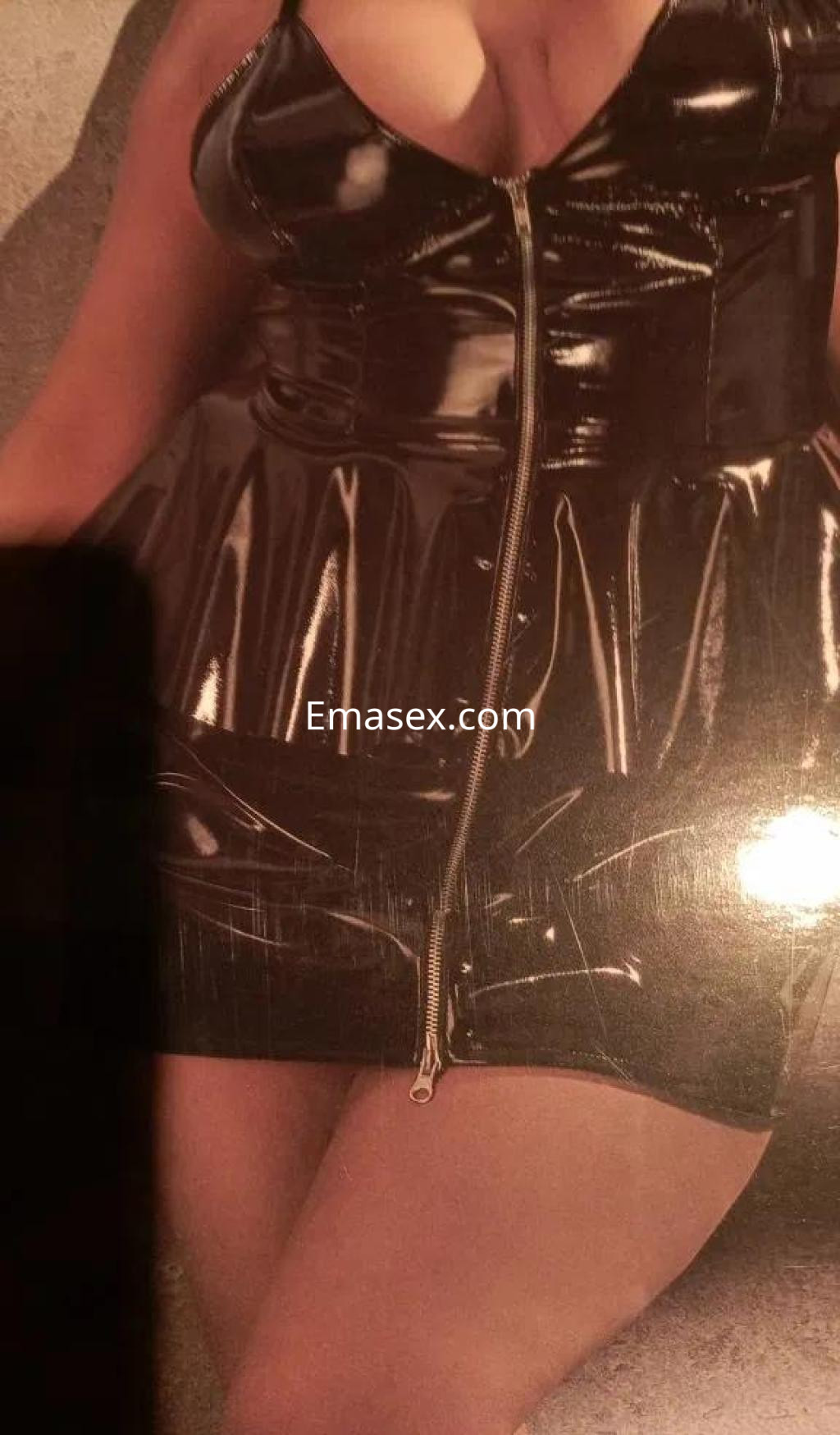 Escort en Oviedo luciendo un vestido ajustado y brillante, con un diseño de peplum y cremallera frontal.