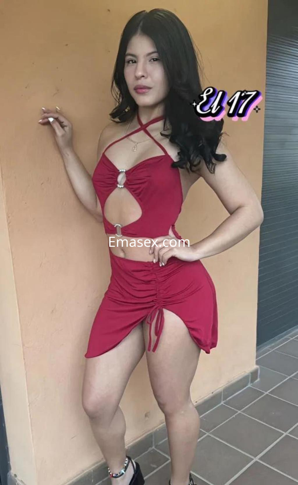 Puta en Las Palmas posando con un vestido rojo ajustado y detalles de corte, mostrando su figura esbelta.