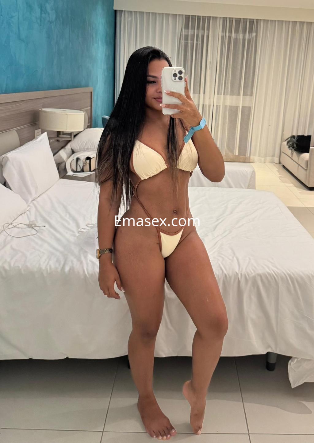 Puta en Bilbao, posando con un bikini amarillo y cabello largo y lacio, frente a un espejo en un hotel.