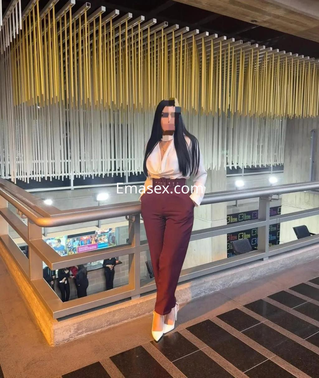 Puta de cabello largo y lacio, viste camisa blanca y pantalón burdeos, posando con tacones en Coruña.