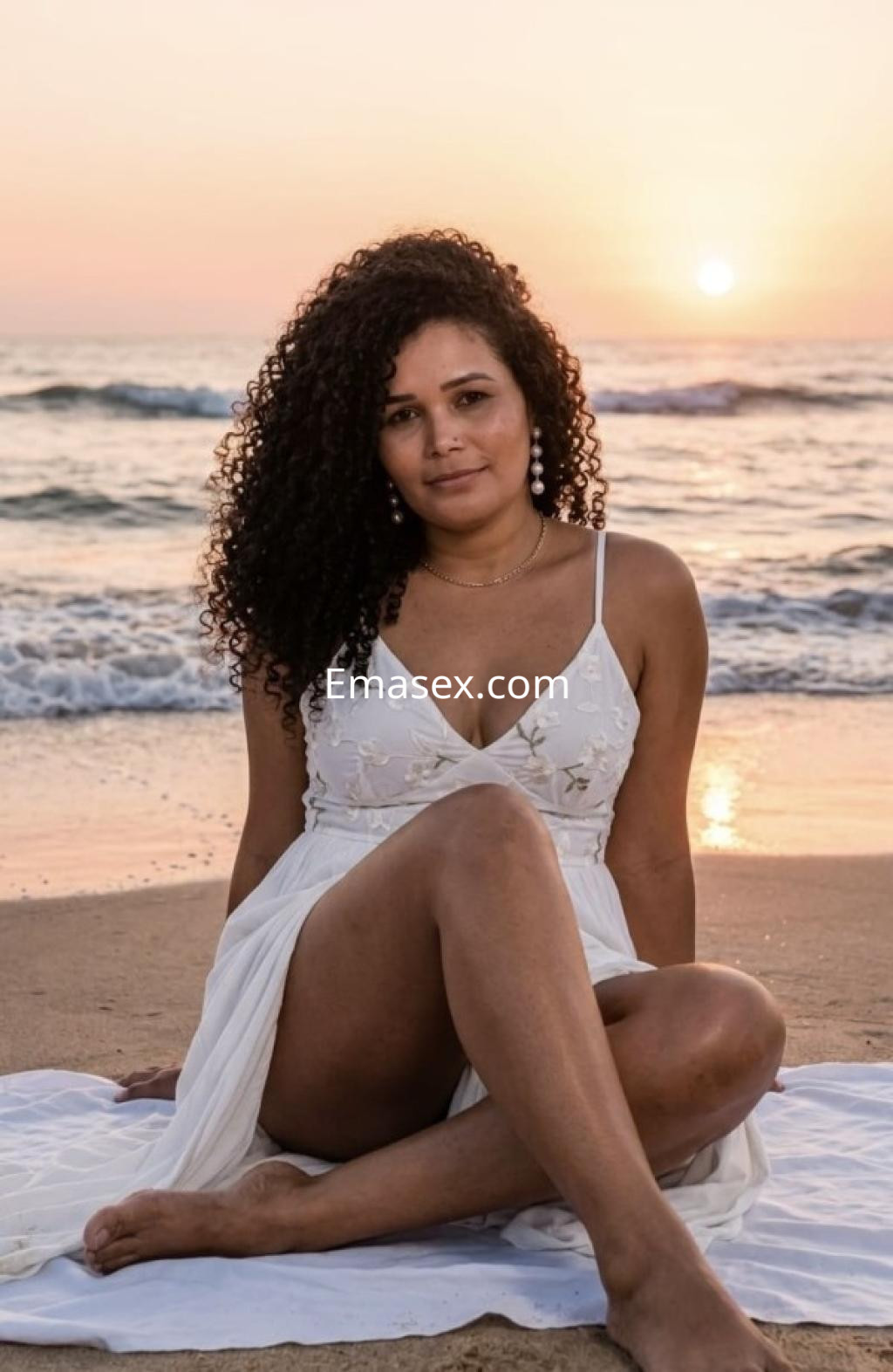La puta luce un vestido blanco y se sienta en la playa de Bilbao, con el sol poniéndose detrás de ella.