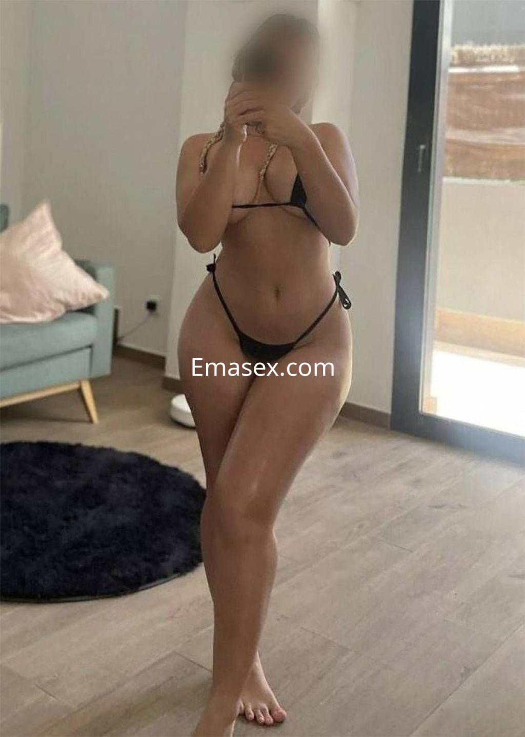 Puta posando en Barcelona, luciendo un bikini negro, con cabello oscuro y un ambiente moderno y luminoso.