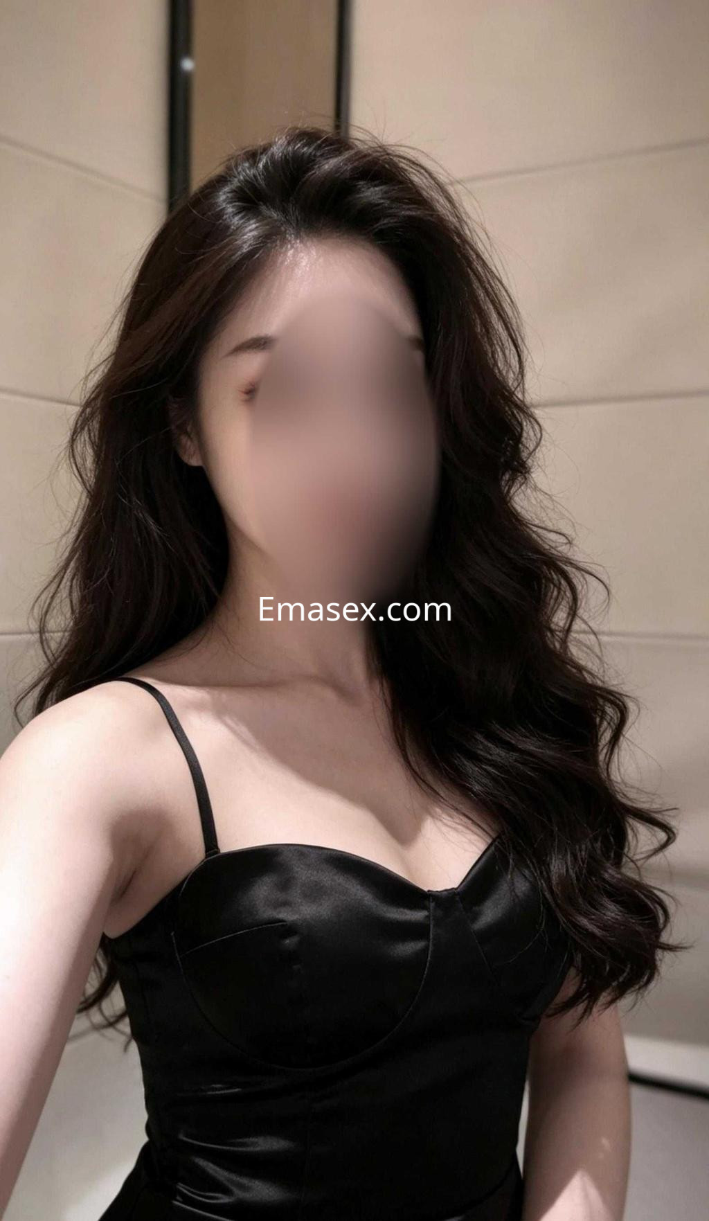 Puta con cabello largo y ondulado, viste un vestido negro sin mangas, en un entorno interior de tonos claros en Madrid.
