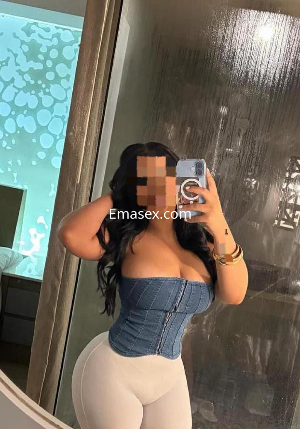 Puta en Pontevedra posando frente a un espejo con corsé de mezclilla y leggins blancos, mostrando una figura curvilínea.