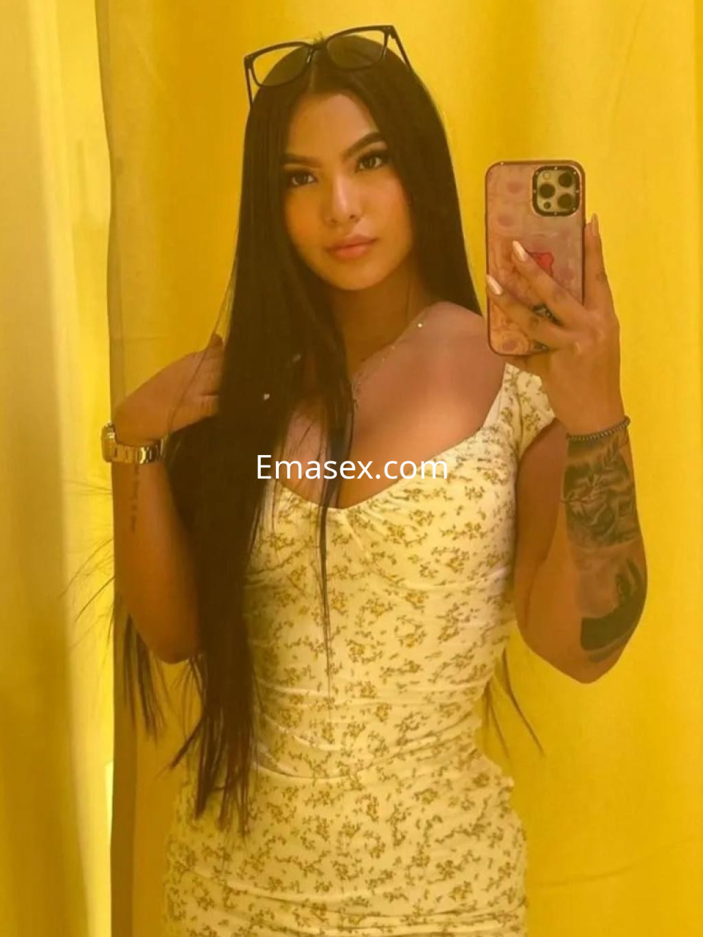Escort en Málaga con cabello largo y lacio, vestida con un vestido amarillo claro, posando frente a un espejo.