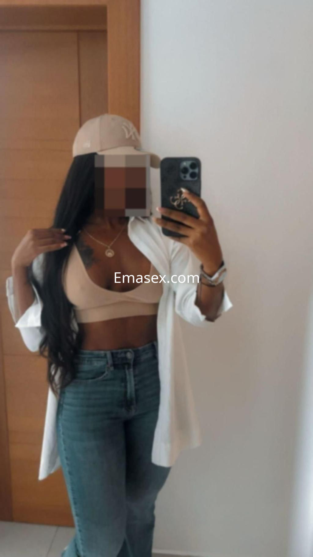 Puta en Albacete, posando con una blusa blanca abierta, sujetador nude y jeans ajustados en un entorno interior.