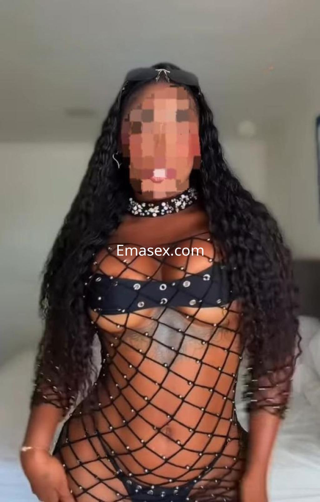 La puta en Almería luce un conjunto de red negro con detalles brillantes, resaltando su figura.