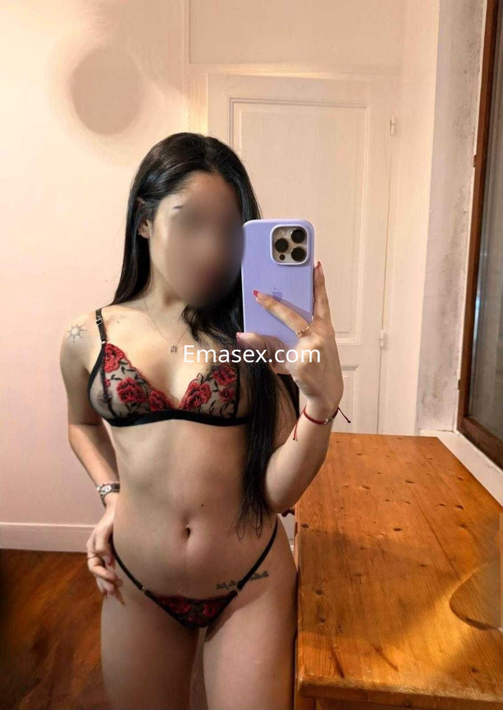 Puta posando en un espejo con lencería negra y roja, en un ambiente interior de Zaragoza.
