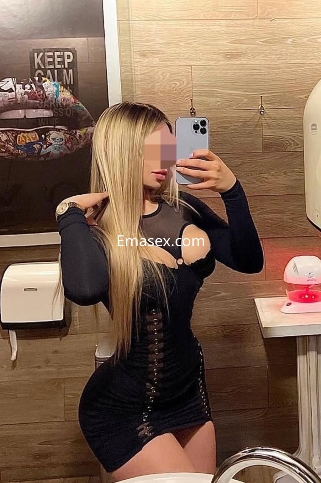 Escort en Castellón posando en un baño, luciendo un vestido negro ajustado y cabello largo y lacio.