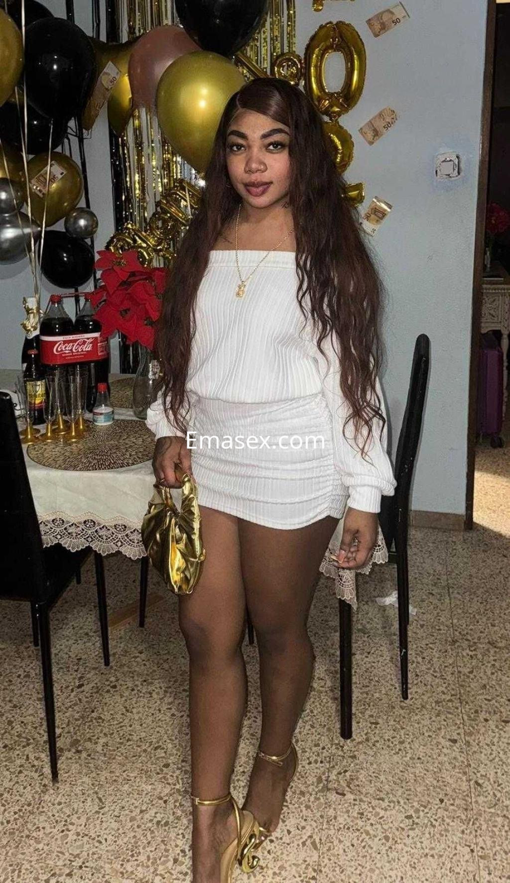 Puta con vestido blanco de manga larga, cabello largo y rizado, en una fiesta decorada en Barcelona.