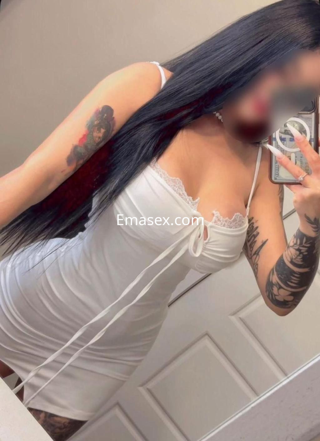 Puta con cabello largo y oscuro, viste un vestido blanco ajustado con encaje, posando en un espejo en Burgos.