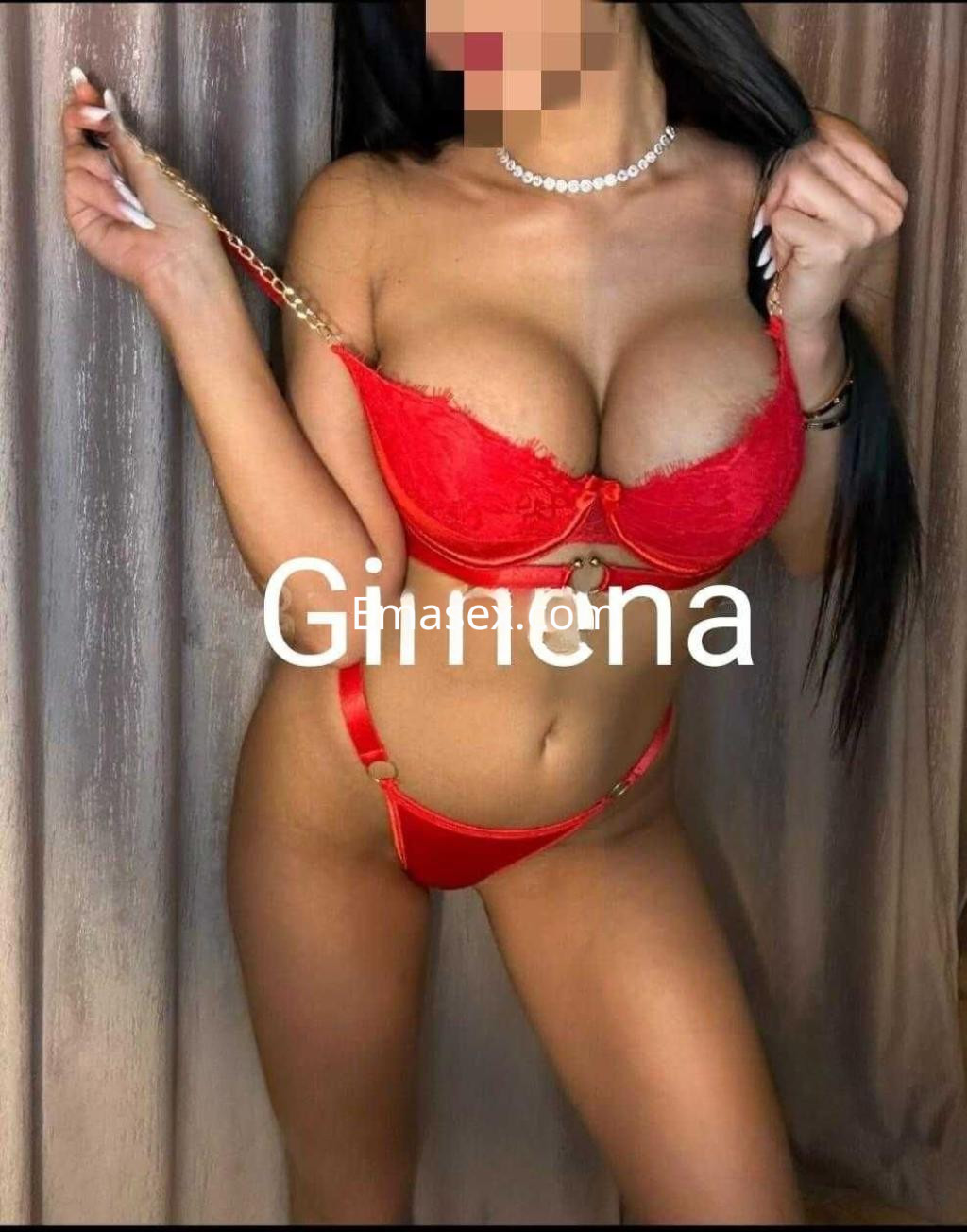 Puta en Córdoba viste lencería roja, con un sujetador que realza su figura y una cadena decorativa.