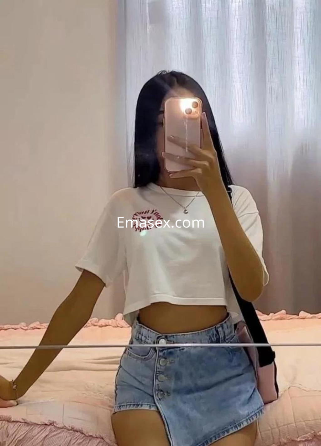 La puta se toma una selfie en Lleida, vistiendo una camiseta blanca corta y una falda de mezclilla.