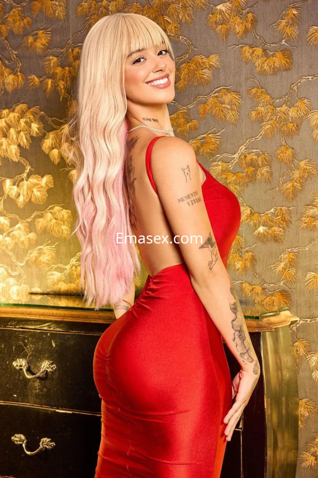 Escort en Valencia con cabello largo y rubio, vistiendo un vestido rojo ajustado que resalta su figura.