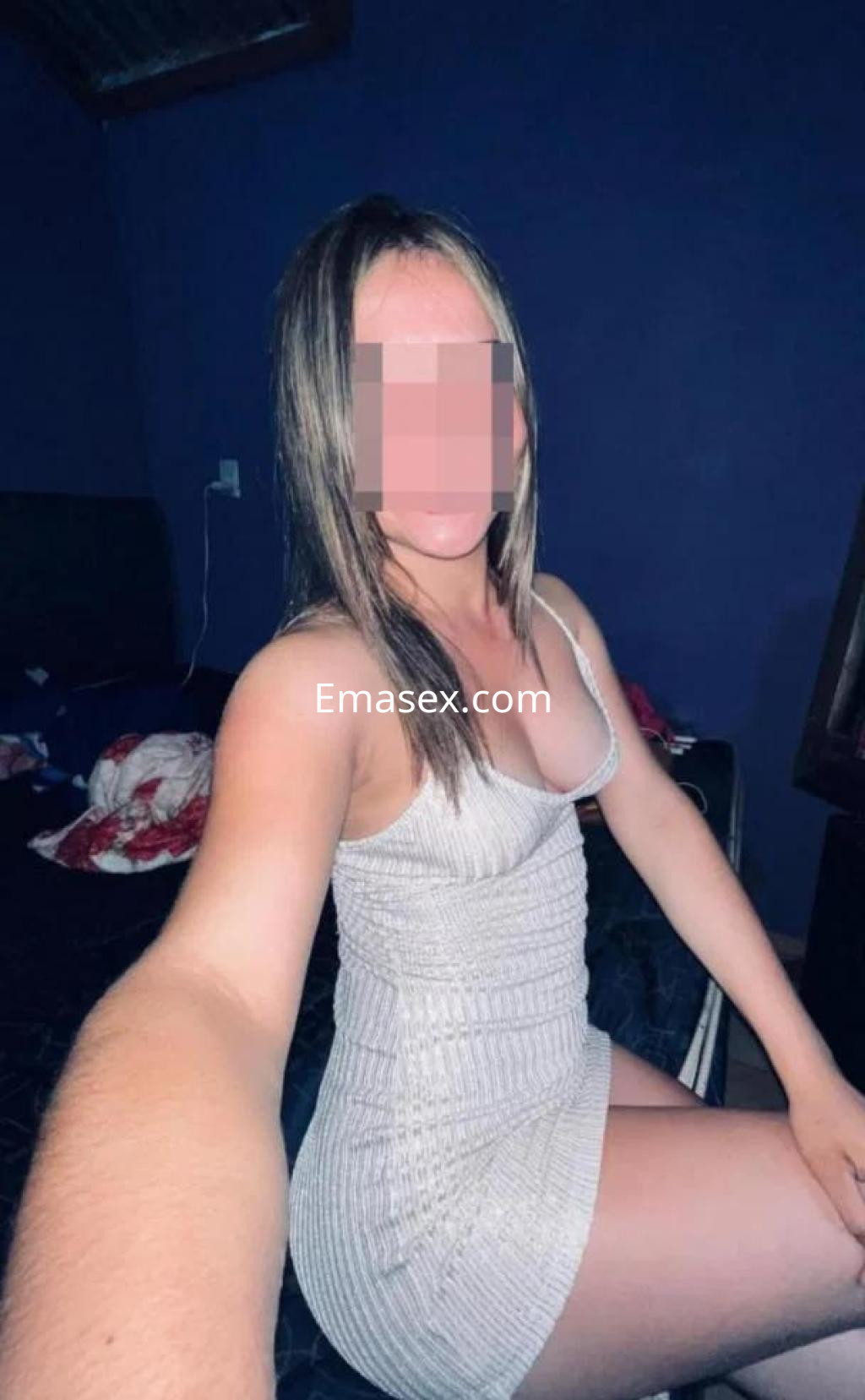 La puta en Zamora posa con un vestido ajustado de color claro, mostrando su figura en un entorno íntimo.