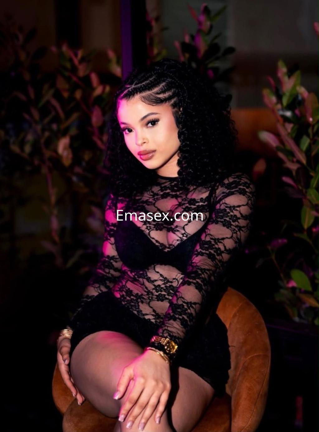 Escort en Santander con cabello rizado y oscuro, vistiendo un conjunto de encaje negro que resalta su figura.