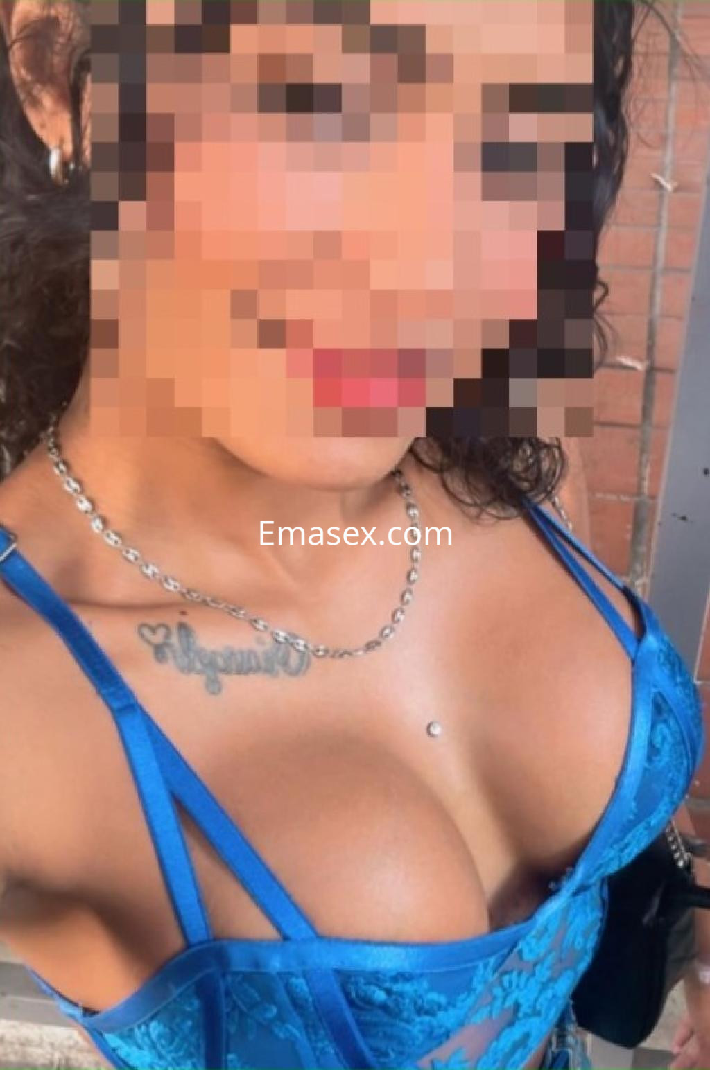 Escort en Salamanca luciendo un vestido azul con encaje, cabello rizado y una sonrisa atractiva.