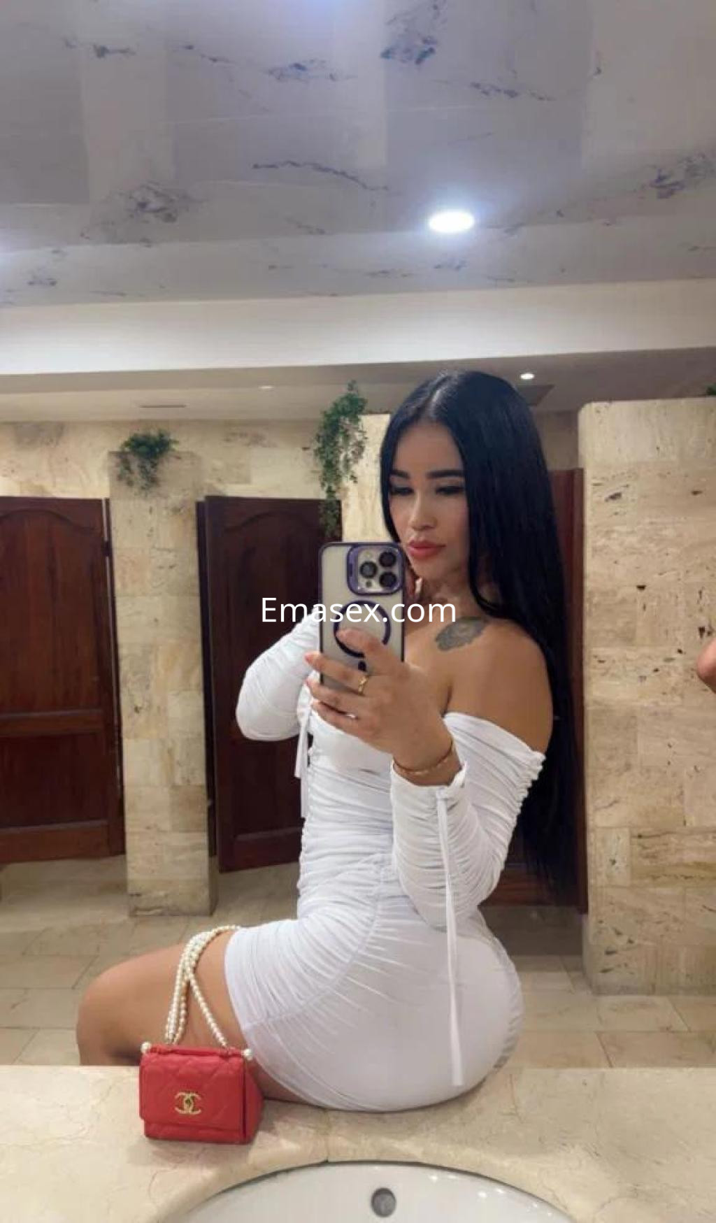 Puta posando en un baño con un vestido blanco ajustado, cabello largo y lacio, en Girona.