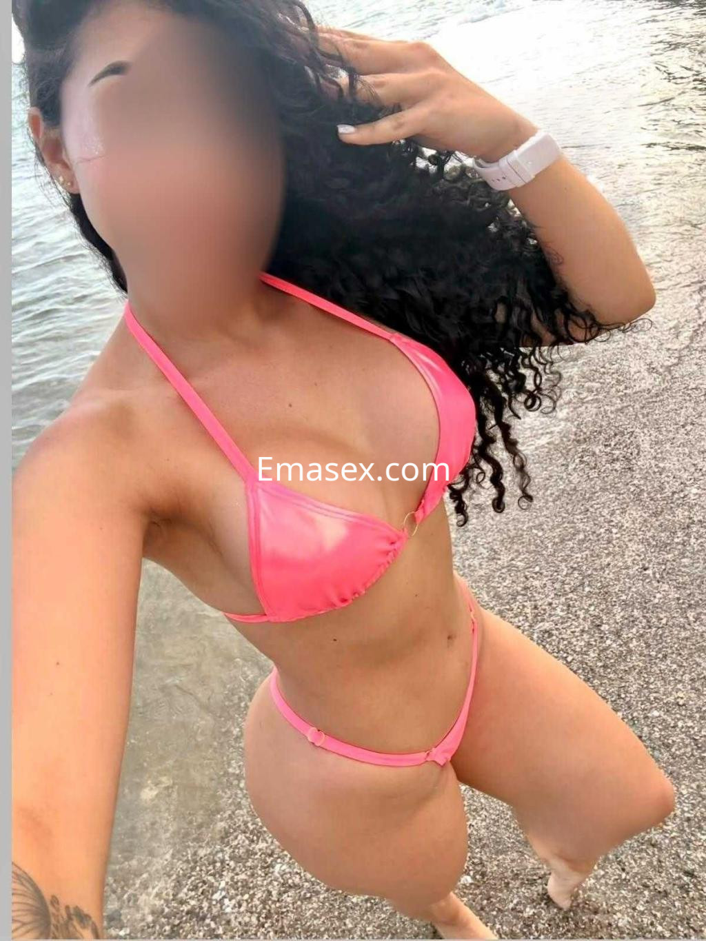 Puta tomando una selfie en la playa de Valladolid, vistiendo un bikini rosa y con el mar de fondo.
