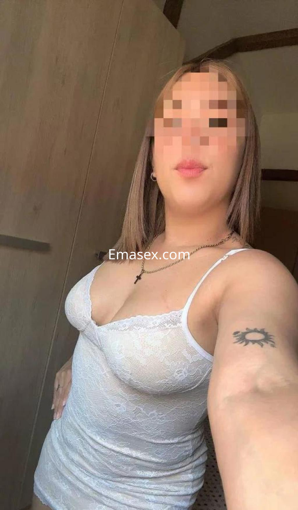 Escort en Almería con cabello lacio y rubio, viste una blusa blanca de encaje que resalta su figura.