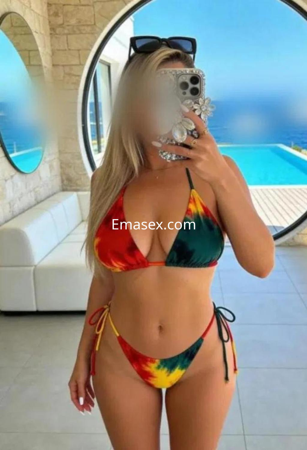 La puta posa en un bikini de colores vibrantes frente a una piscina en Sevilla, mostrando confianza.