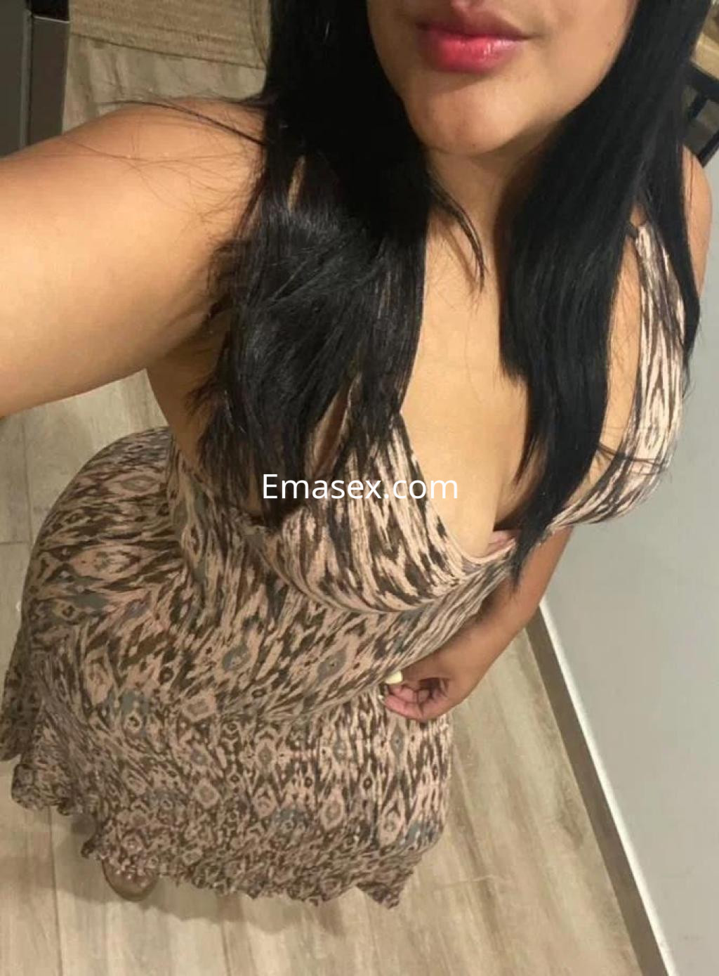 Escort en Sevilla con vestido de estampado animal, cabello largo y lacio, posando de forma coqueta.