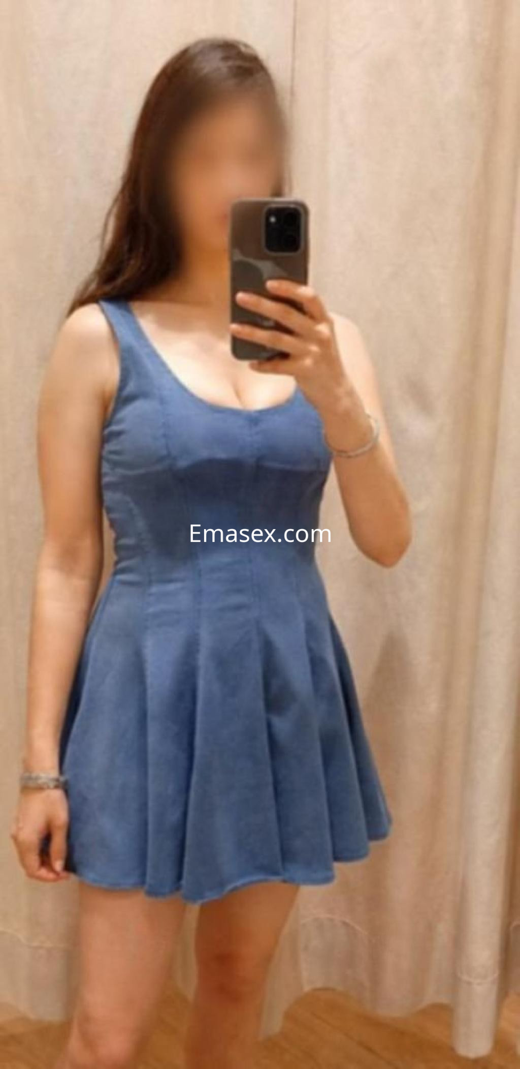 La puta viste un vestido azul claro, ajustado en la parte superior y con falda amplia, en un entorno de vestidor en Vigo.