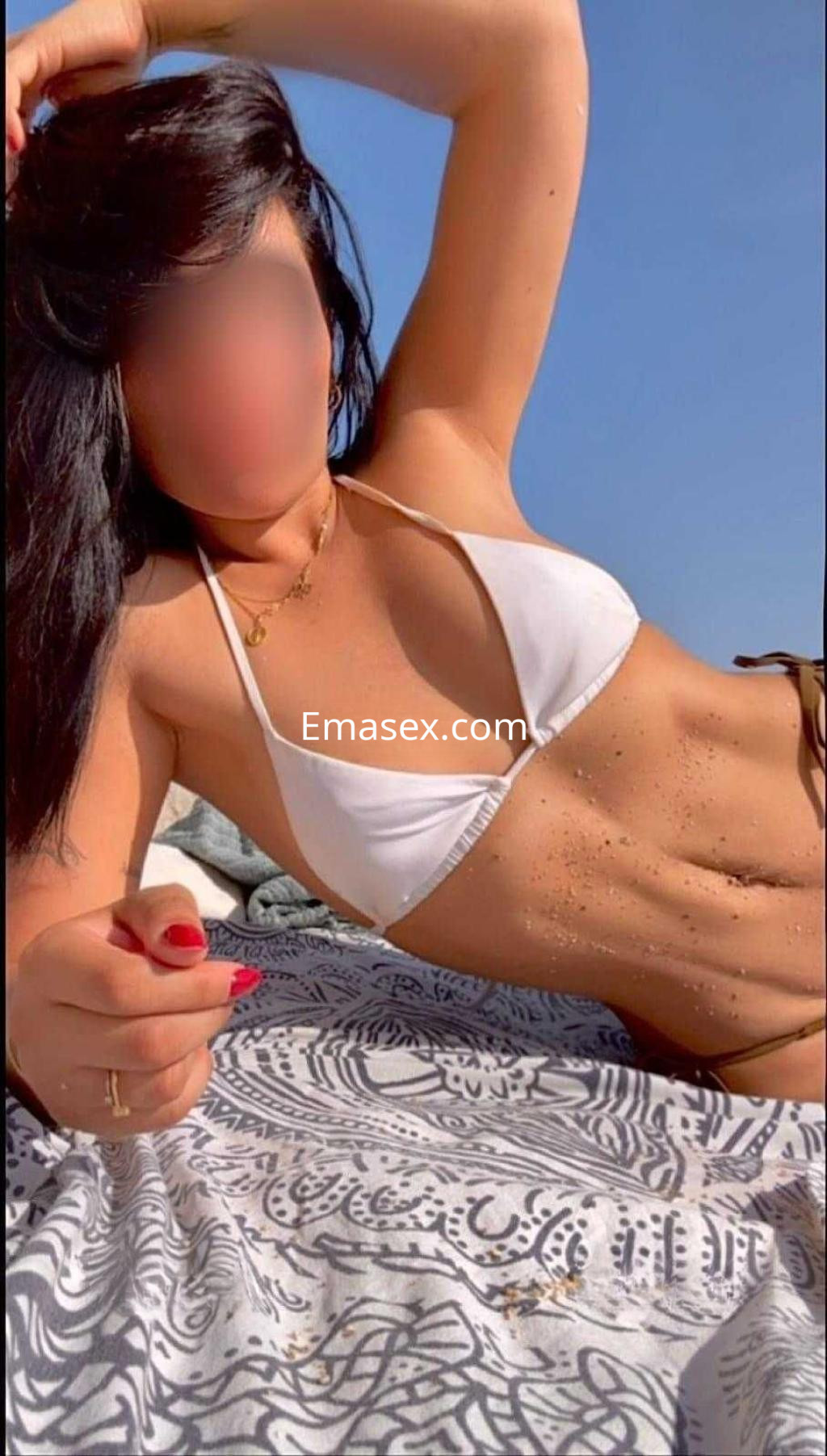 Puta en Vigo, posando con un bikini blanco en la playa, con el sol iluminando su piel bronceada.