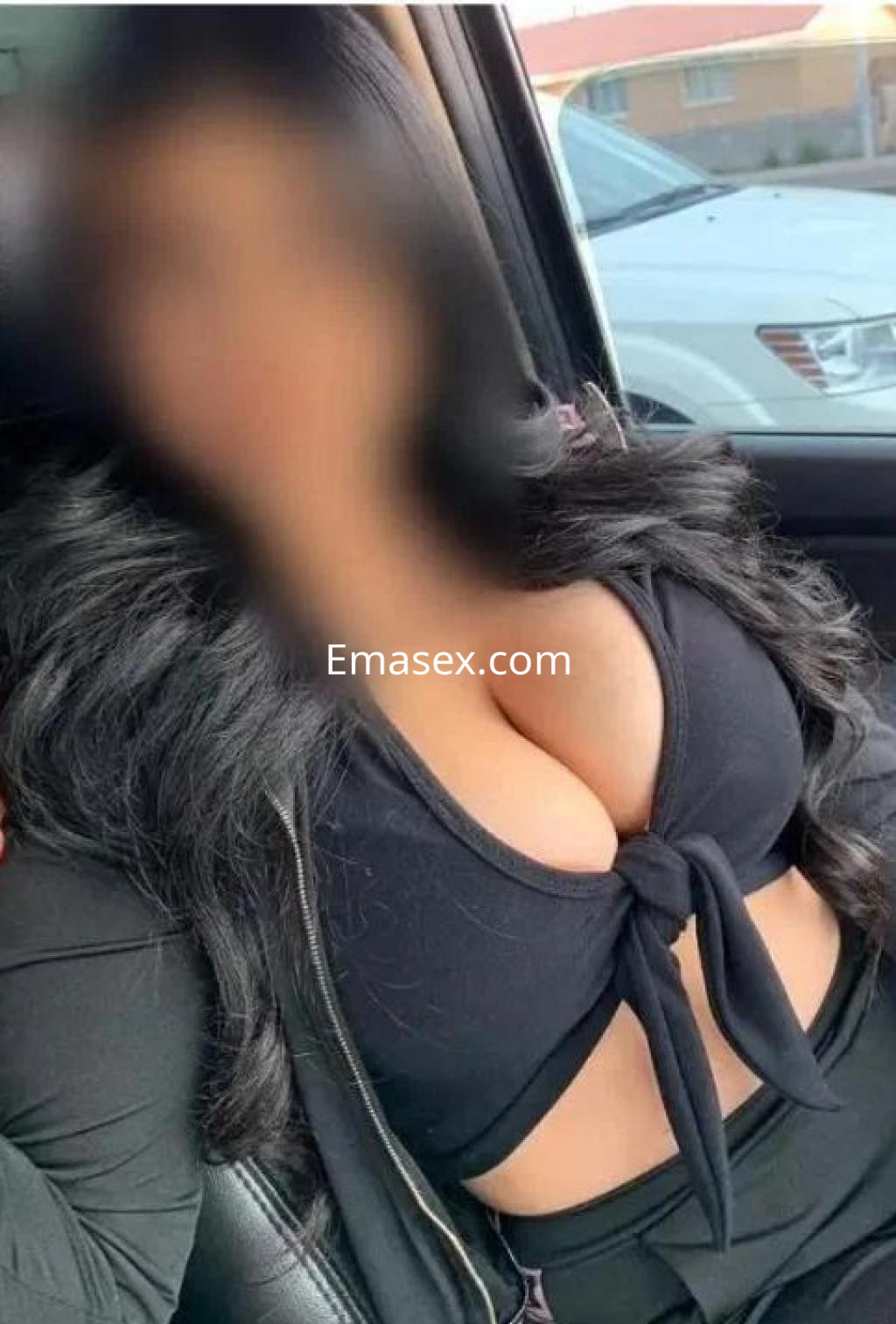 Escort en Cádiz con cabello largo y oscuro, vistiendo un top negro ajustado que resalta su figura.