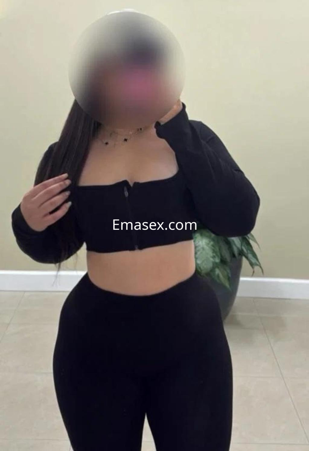 Escort en Tenerife con cabello largo y lacio, vistiendo un conjunto negro ajustado que resalta su figura.