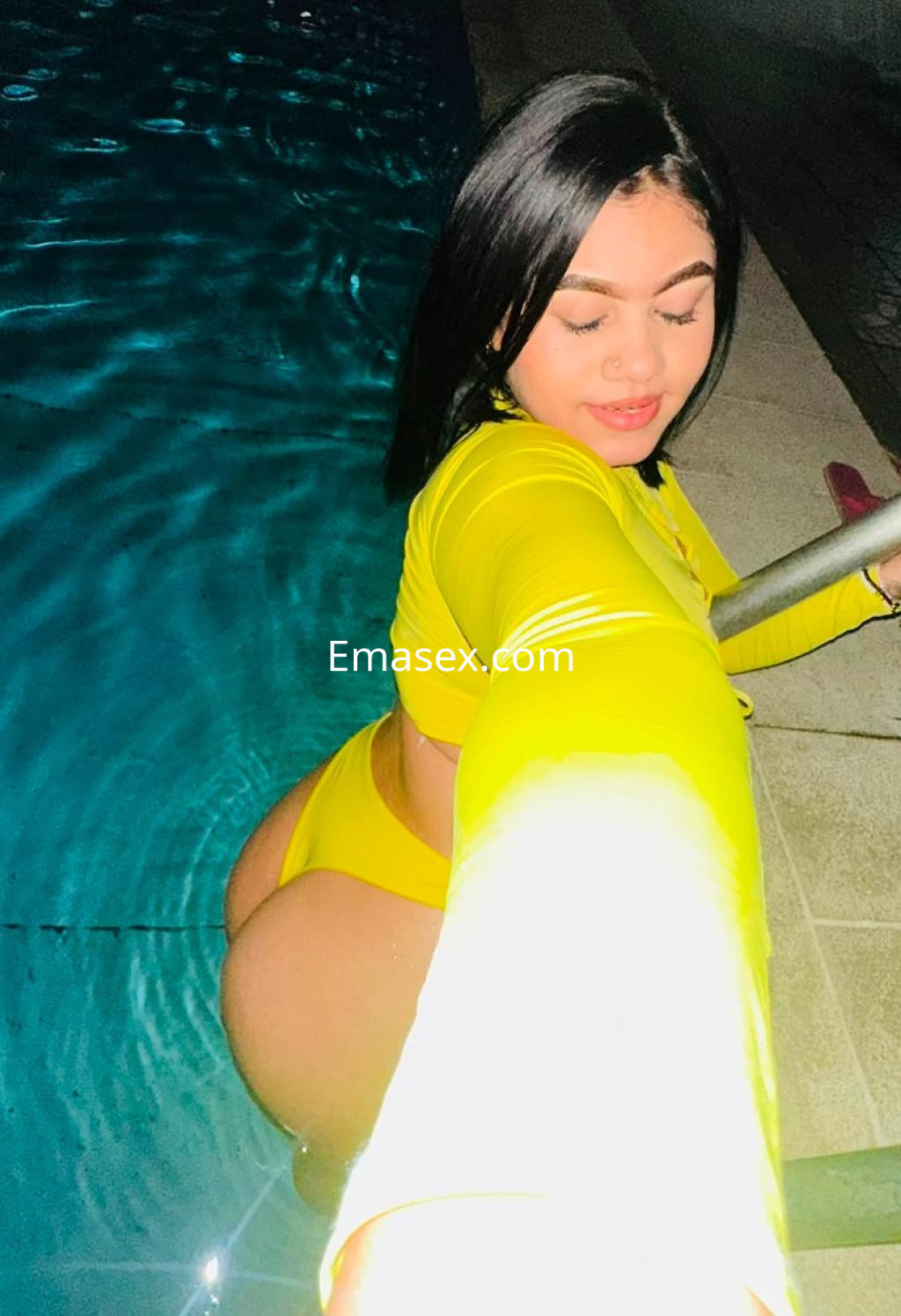 Puta en Irún, posando junto a una piscina, luciendo un bikini amarillo y con cabello oscuro y lacio.