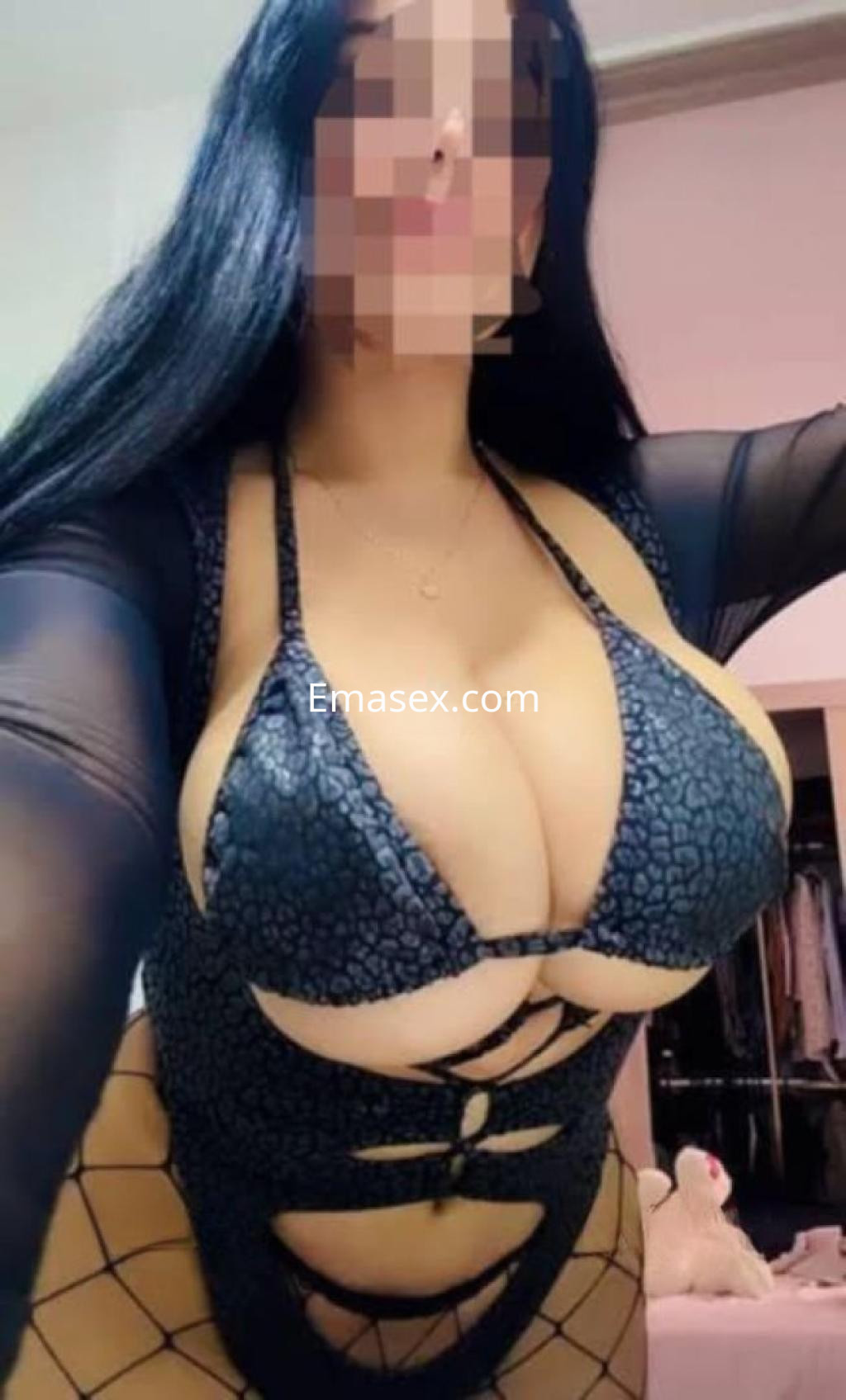 Escort en Barcelona con cabello largo y lacio, vistiendo un atrevido body negro con detalles de malla.