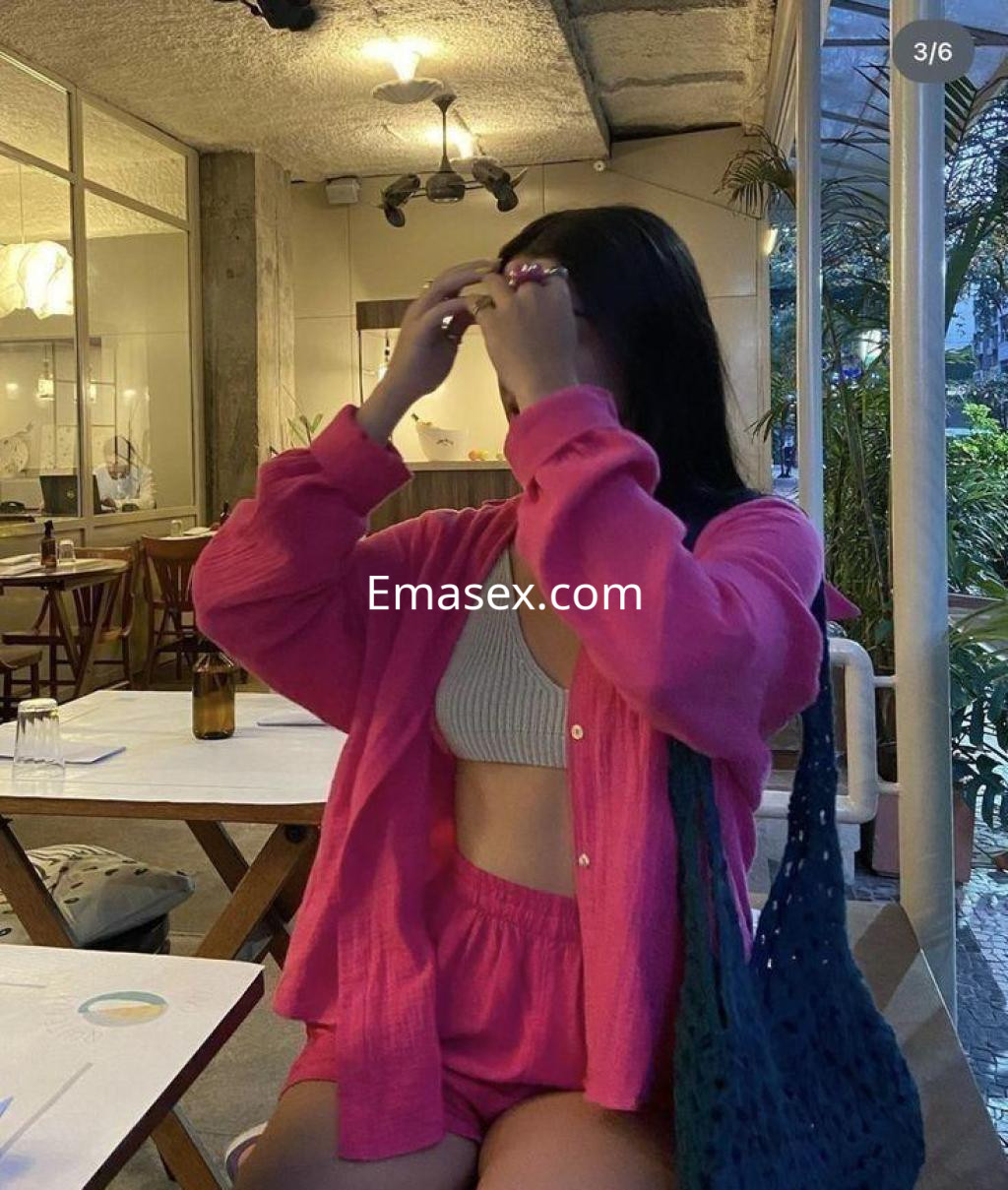 Puta en Coruña viste un conjunto rosa con blusa abierta y pantalones cortos, en un ambiente acogedor.