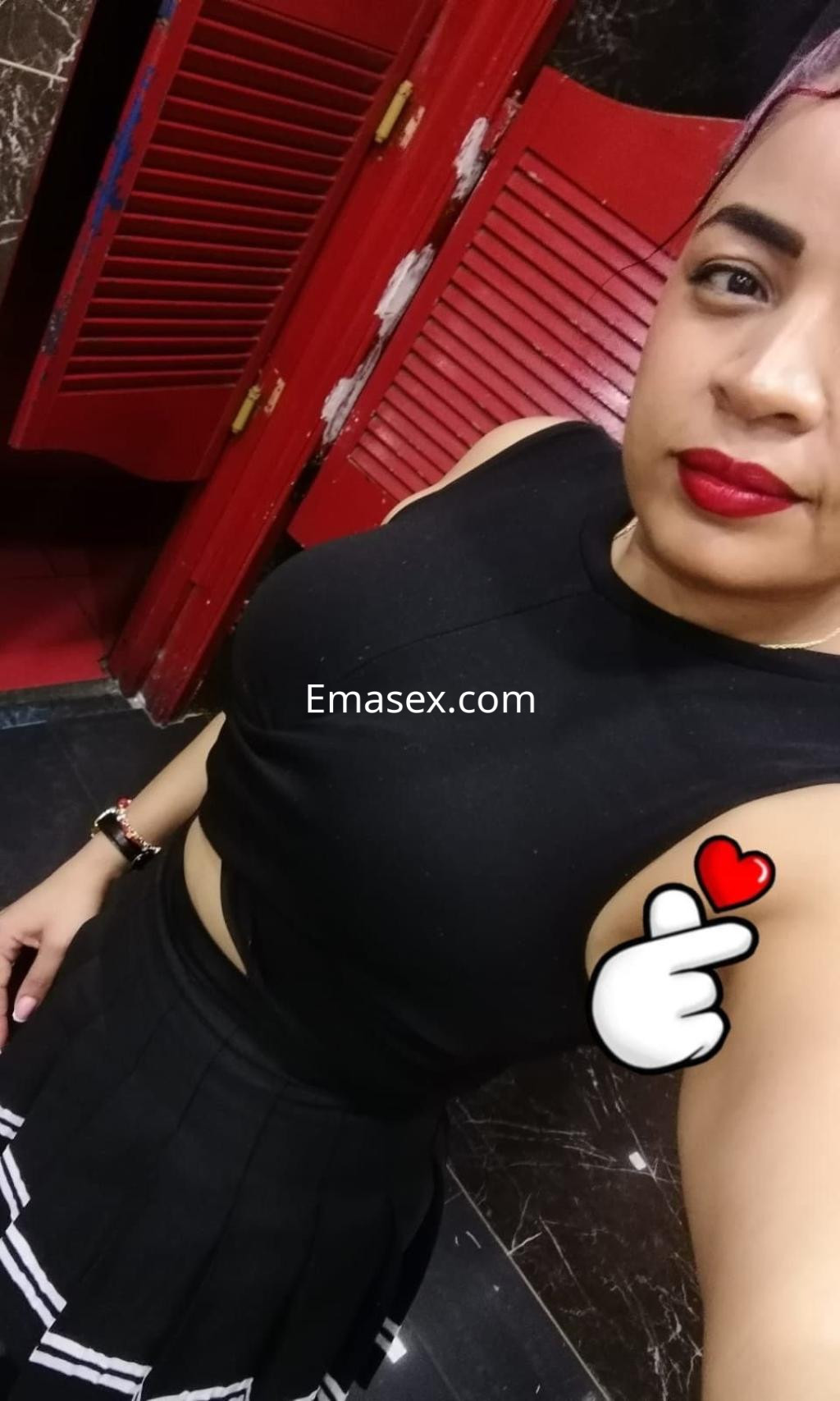 Puta de cabello corto y rubio, viste un top negro y una falda corta, posando en un baño en Cádiz.