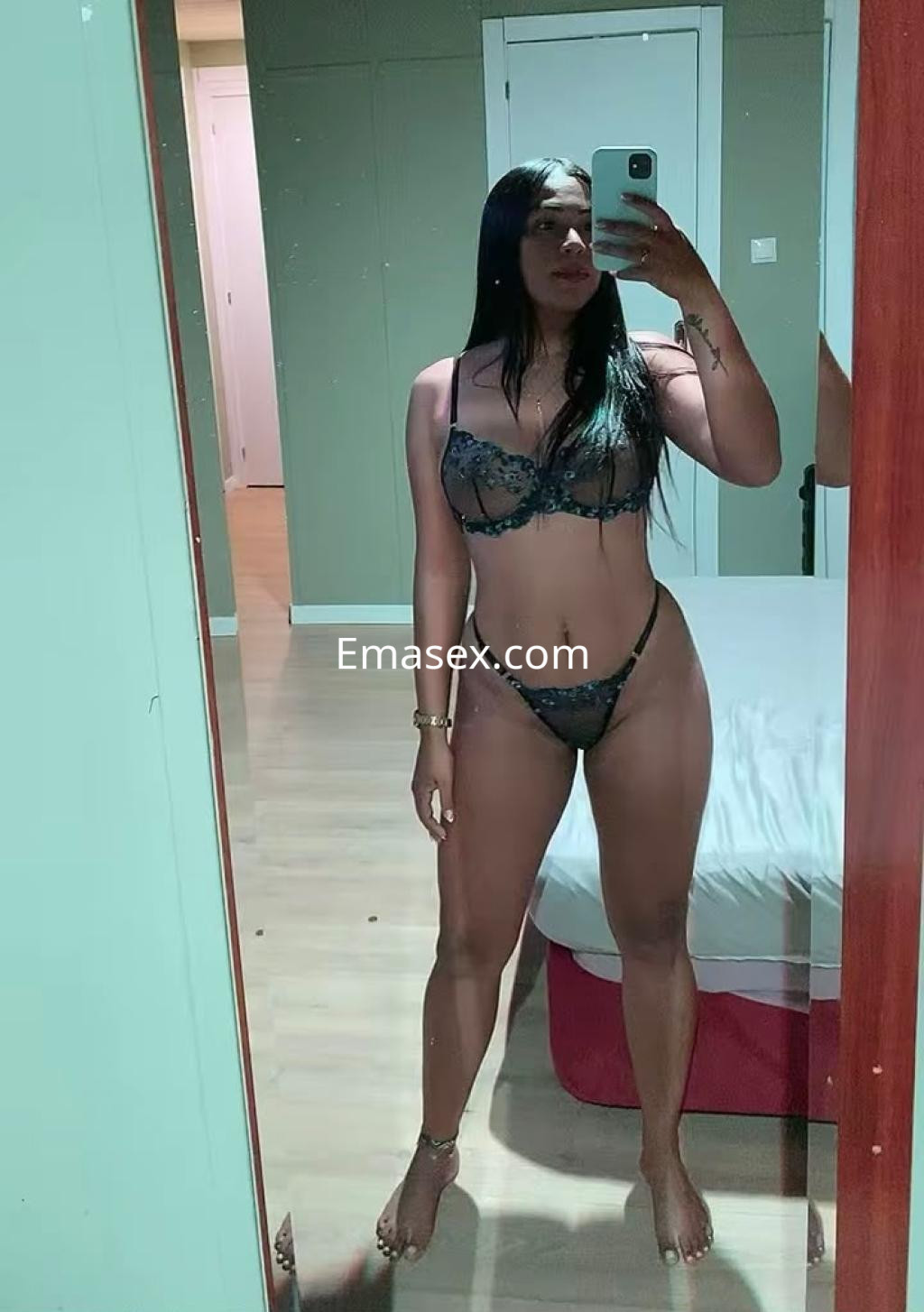 Escort en Bilbao posando frente a un espejo, vistiendo un conjunto de lencería negra y mostrando su figura.