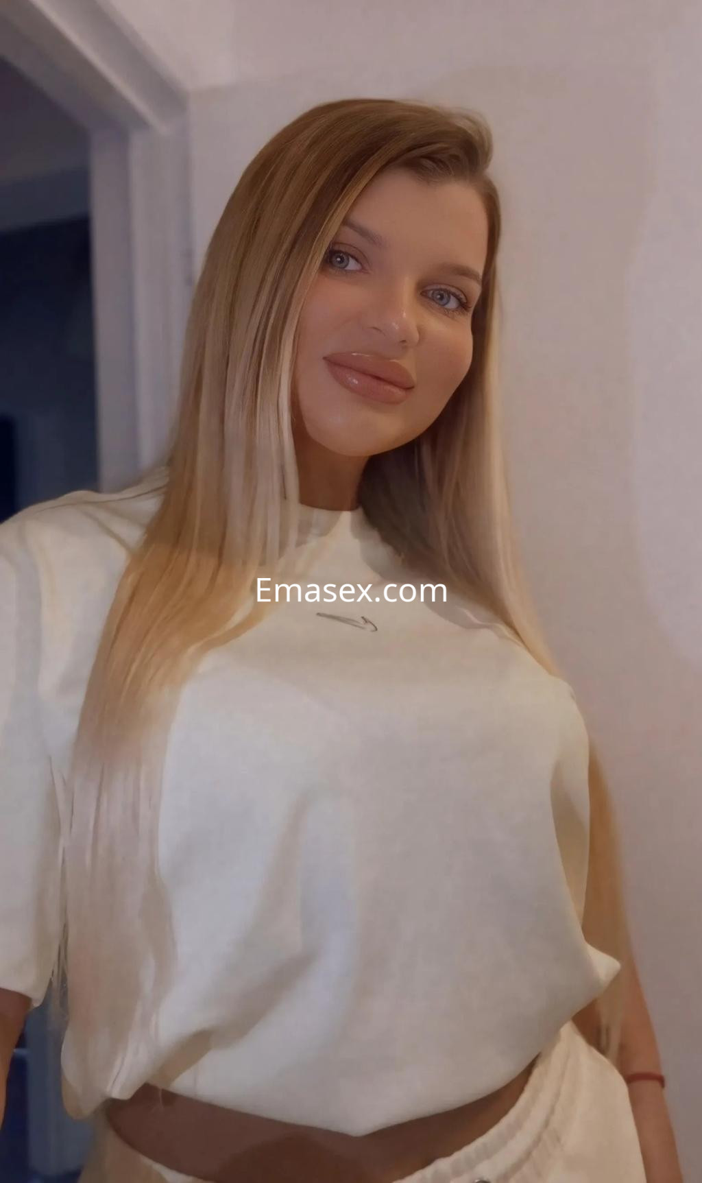 Escort en Palma de Mallorca con cabello largo y lacio, vestida con una camiseta clara y pantalones cómodos.