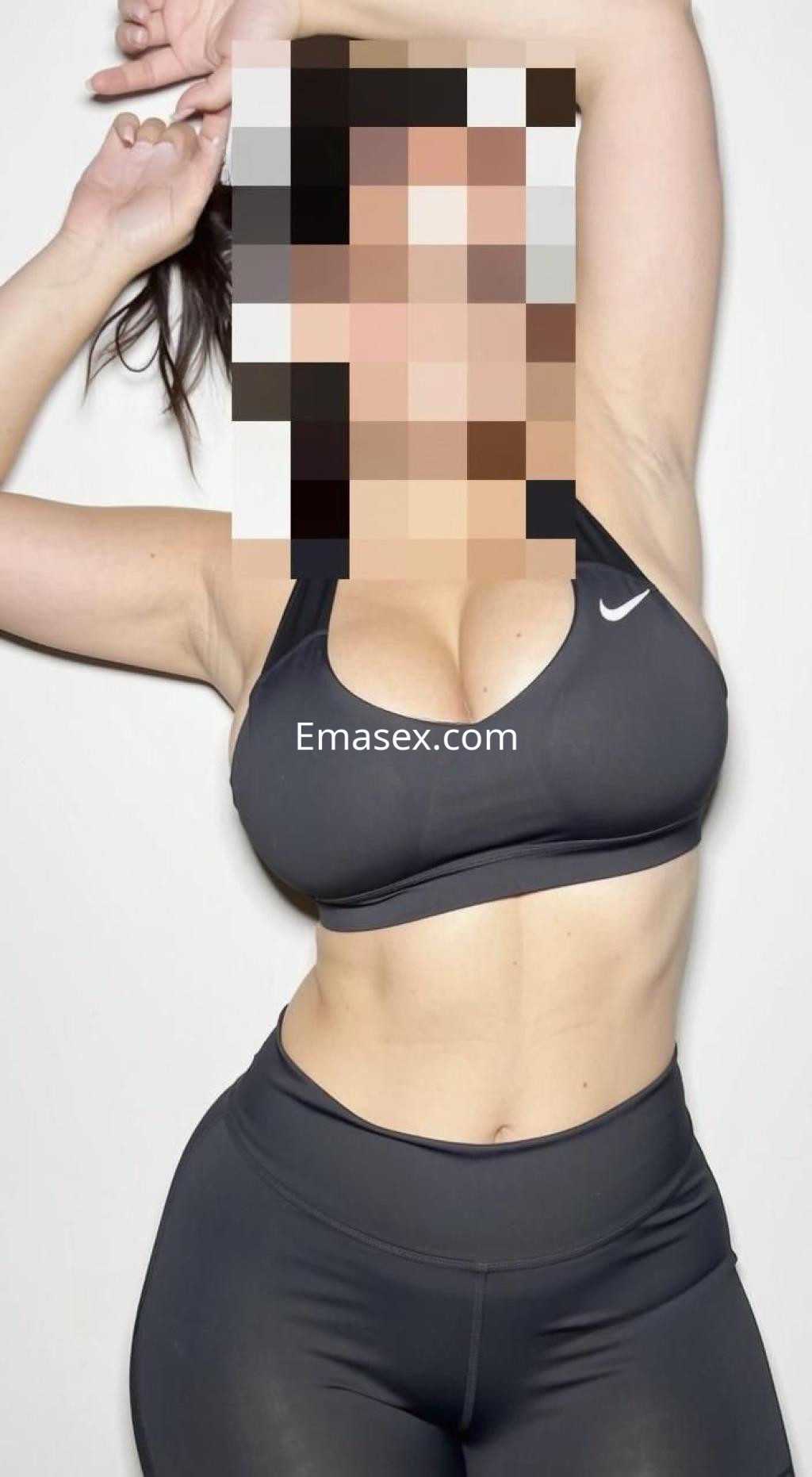 Escort en Madrid posando con una camiseta deportiva negra y leggings ajustados, mostrando confianza y estilo.