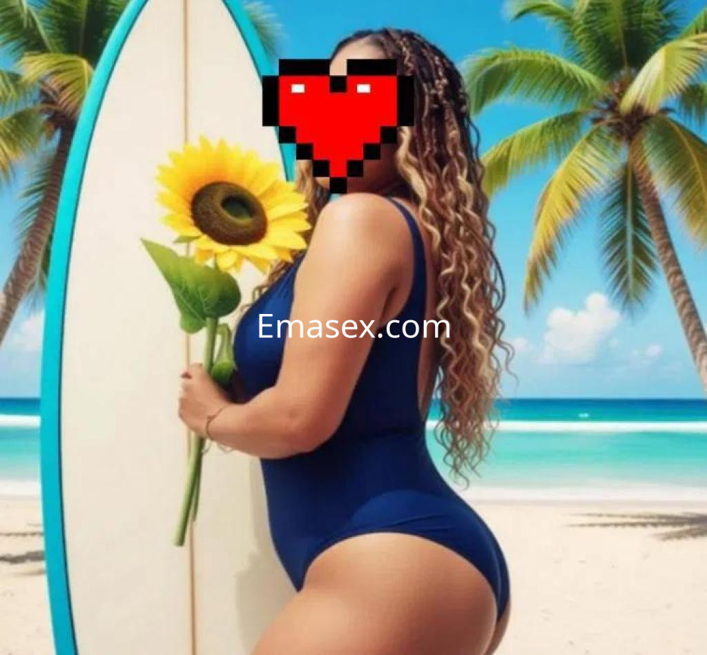 La puta muestra un bañador azul, sosteniendo un girasol junto a una tabla de surf, en una playa de Salamanca.