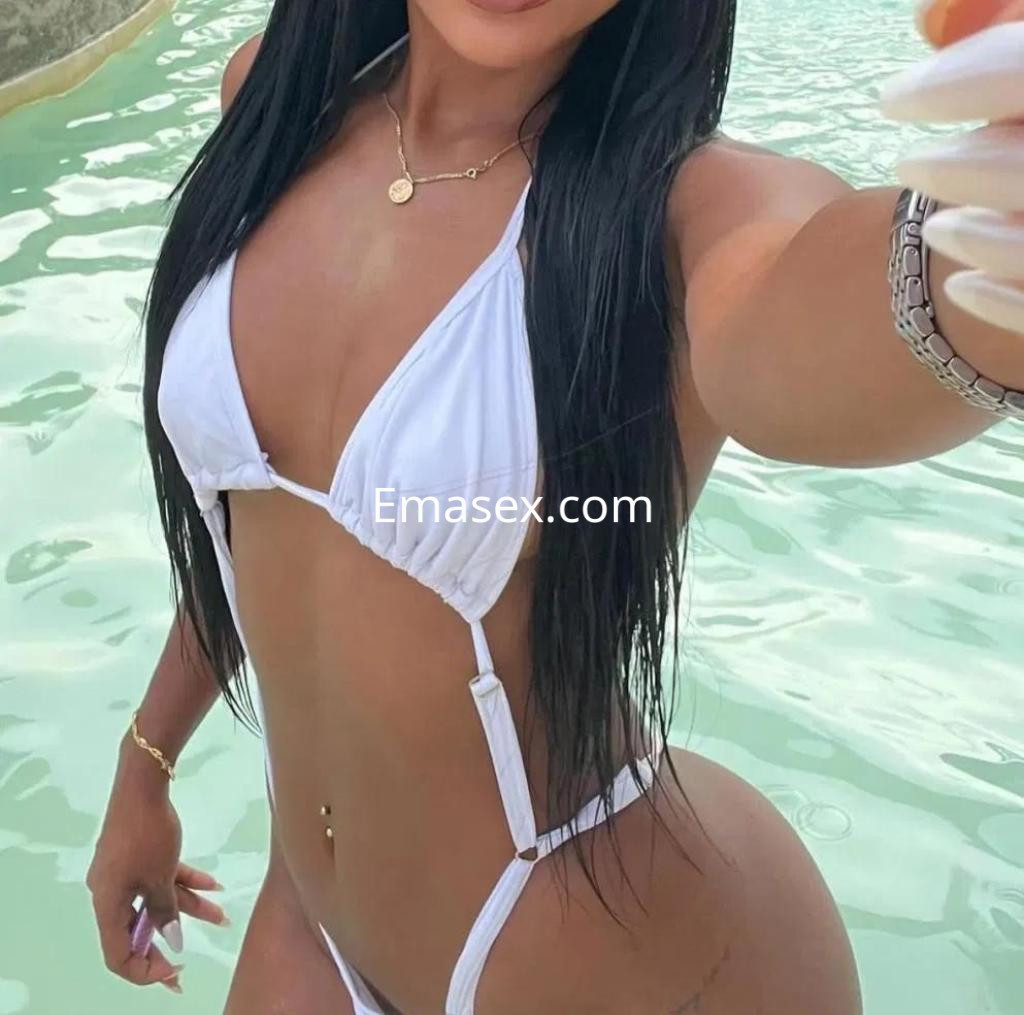 La puta posa con un bikini blanco en un entorno acuático, mostrando su cabello largo y piel bronceada en Cádiz.