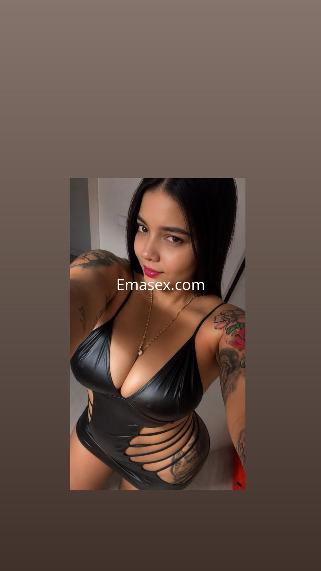 Escort en Salamanca posando con un traje de baño negro ajustado y detalles recortados, mostrando tatuajes y una sonrisa.