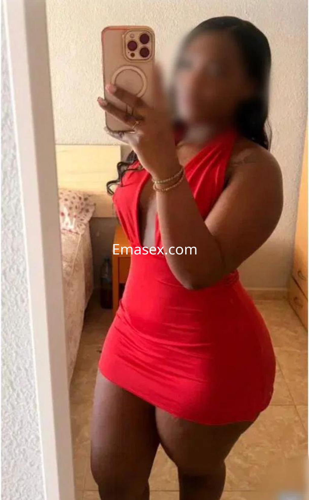 Puta en Castellón con vestido rojo ajustado que resalta su figura, posando frente a un espejo.